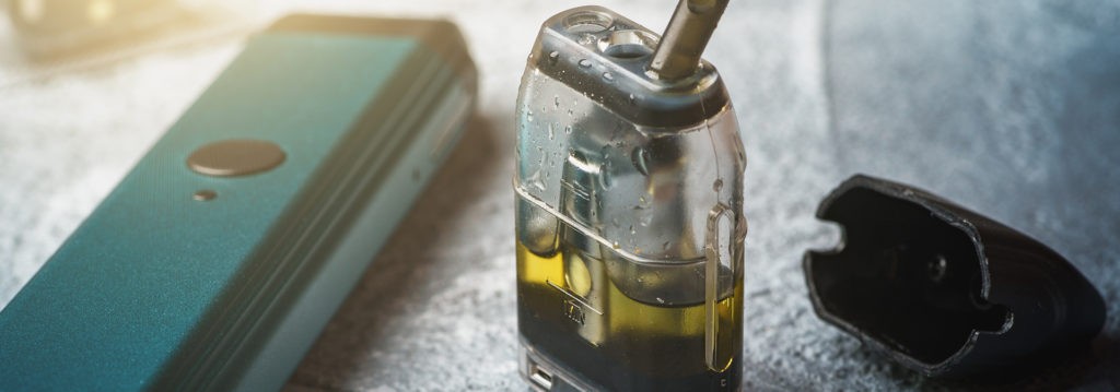 Un vaporisateur DIY avec une bouteille d’e-liquide à côté.
