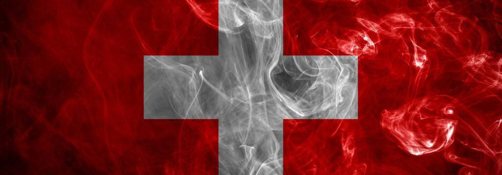 Eine Schweizer Flagge mit Rauch darauf.